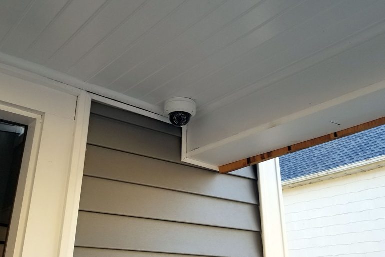 Dome security camera beneath a residential porch roof